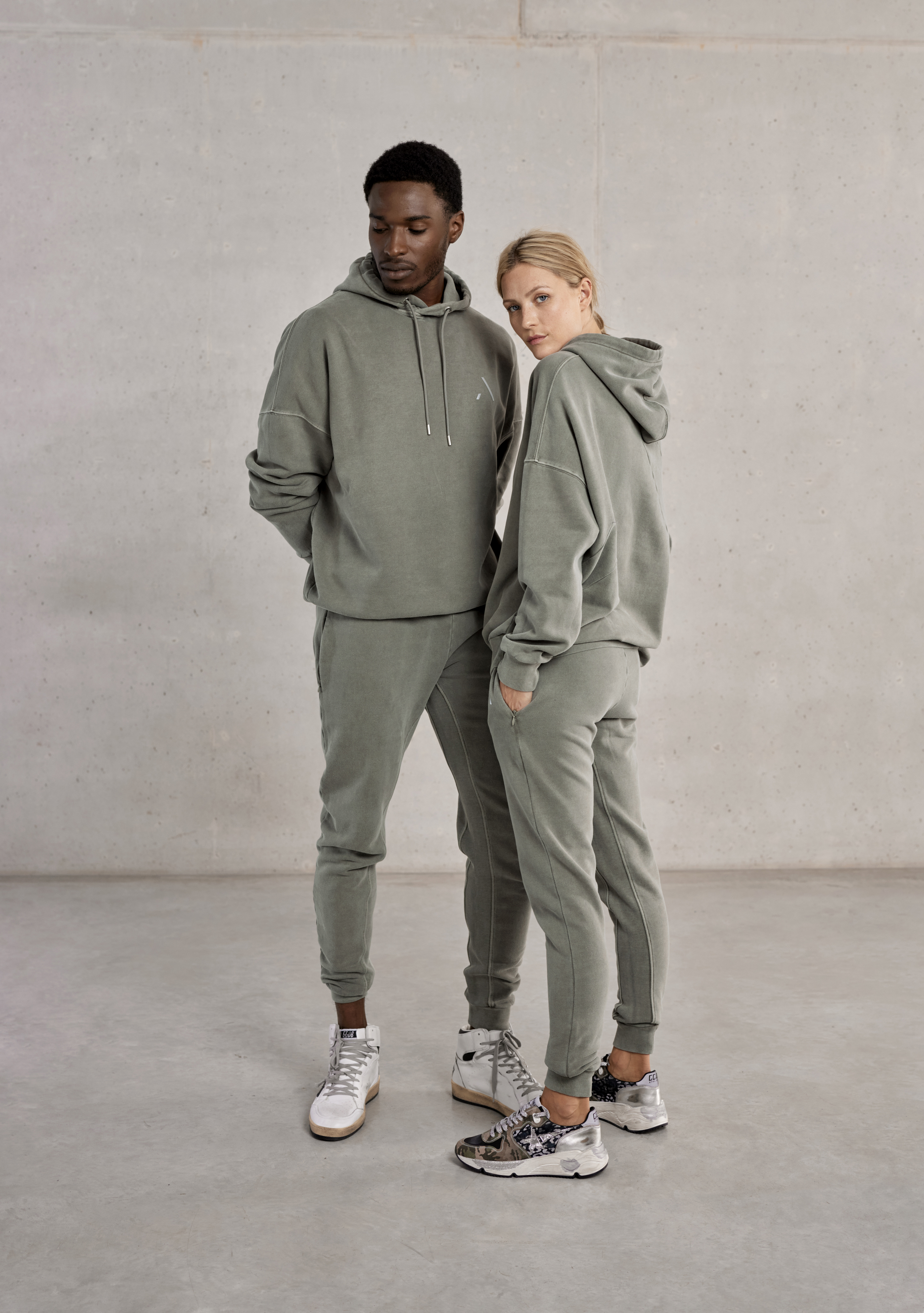 ayms-modern-luxury-activewear-2023-matar-menkar-ay0321010106020300-hoodie-merga-ay0321010107000300-jogger-oil-green-unisex-couple-front-side-2-modern-luxury-lifestyle-authentic-athleisure